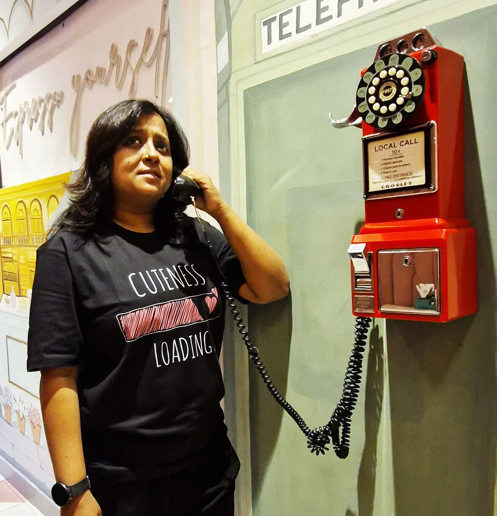 Woman wearing Black themed Cuteness Loading T-shirt and talking over the phone